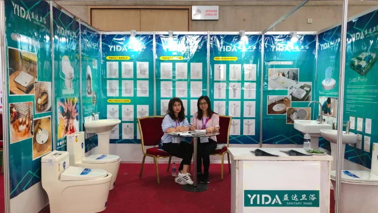 YIDA sales consultants at 2018 Bangladesh Expo, with ceramic toilets and basin product posters in the background