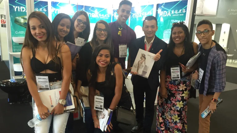 YIDA team with Brazilian students and designers at 2018 Brazil Construction Expo, holding YIDA product catalogs