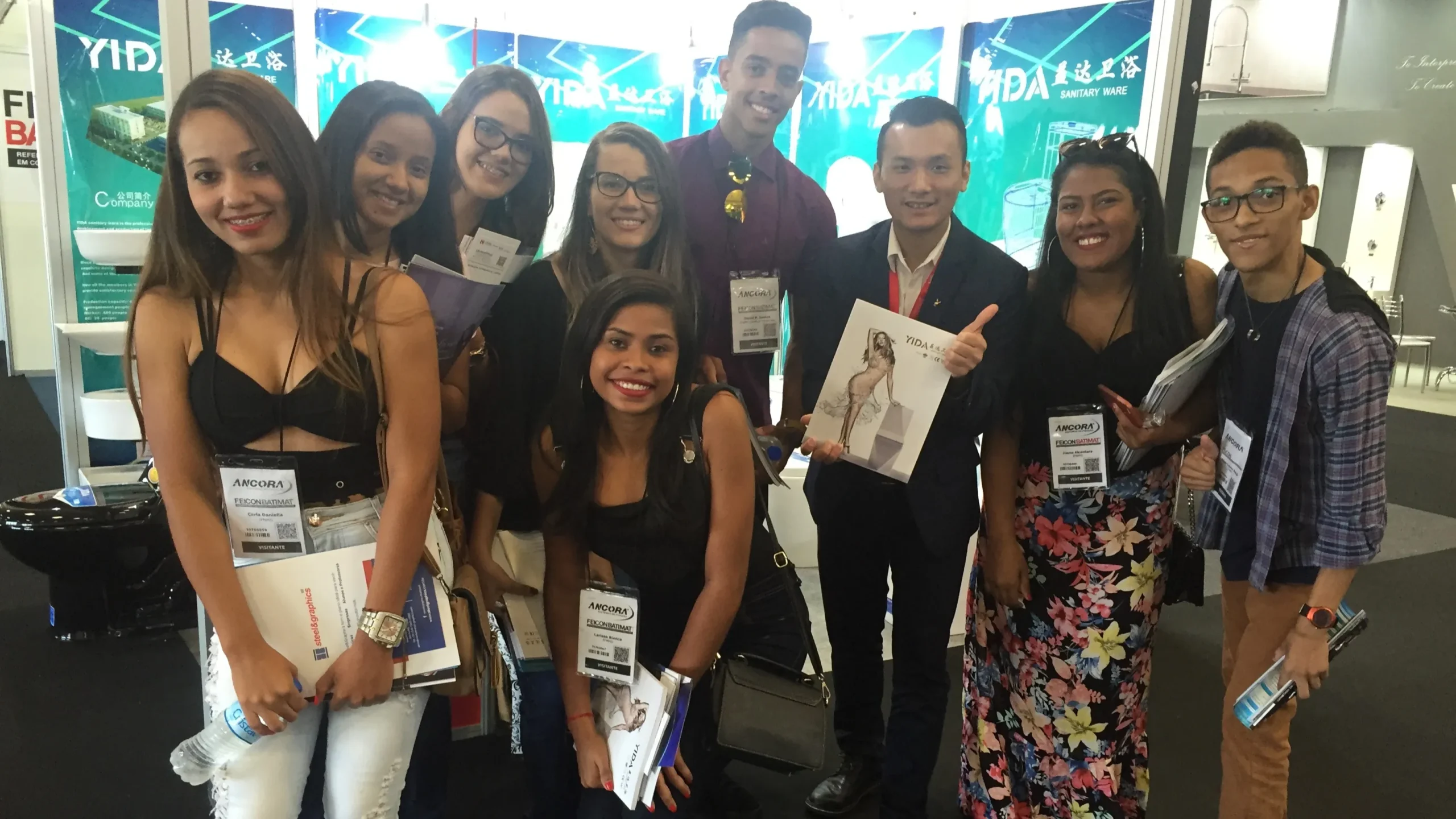 YIDA team with Brazilian students and designers at 2018 Brazil Construction Expo, holding YIDA product catalogs